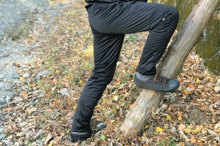 ワークマンプラス フィールドコア　エアロストレッチ クライミングパンツを男性が着て、足をのばしている